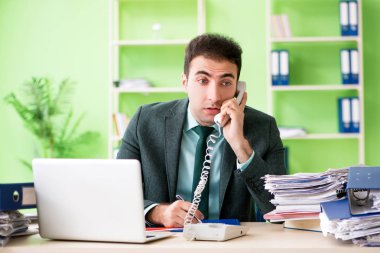 İşadamı ofiste otururken aşırı çalışmaktan kızgın.