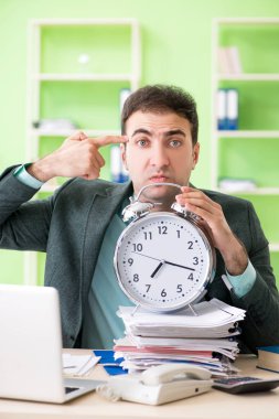 Ofiste otururken aşırı çalışmaktan kızgın bir iş adamı.