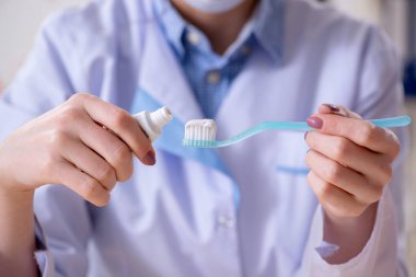 Kadın dişçi, diş modeli üzerinde çalışıyor.