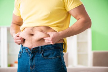 Diyet konseptinde genç şişman adam 