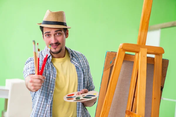 Jovem artista masculino trabalhando em nova pintura em seu estúdio — Fotografia de Stock