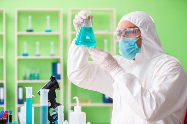 Laboratuvarda yeni bir deney üzerinde çalışan kimyager.