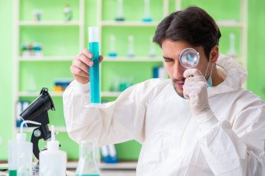 Laboratuvarda yeni bir deney üzerinde çalışan kimyager.
