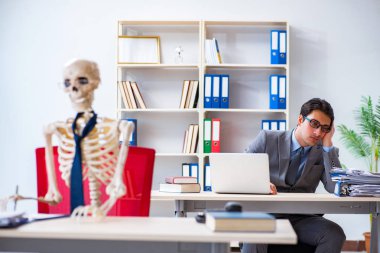 İskeletle çalışan bir iş adamı.