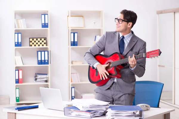 Jeune homme d'affaires beau jouant de la guitare dans le bureau — Photo