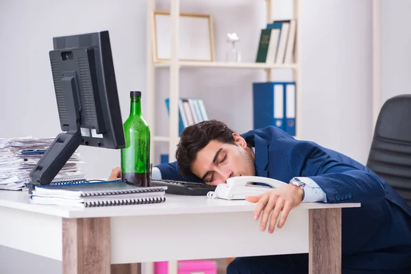 Jovem empresário empregado bebendo no escritório na mesa — Fotografia de Stock