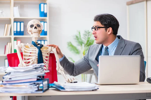 Businessman working with skeleton in office — Stock Photo, Image