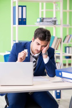 İşadamı ofiste aşırı çalışmaktan memnun değil. 