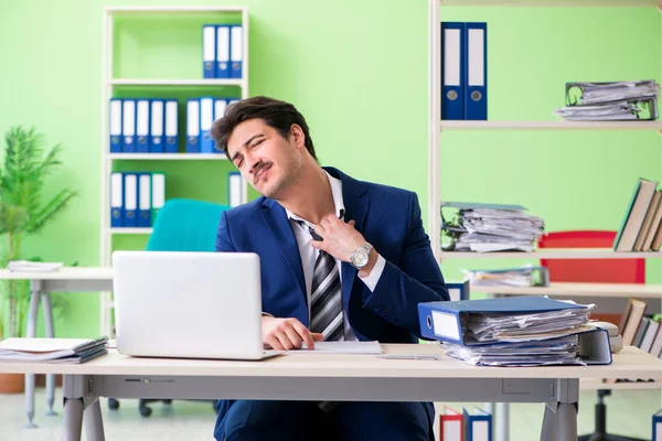 Empresario descontento con el trabajo excesivo sentado en la oficina —  Fotos de Stock