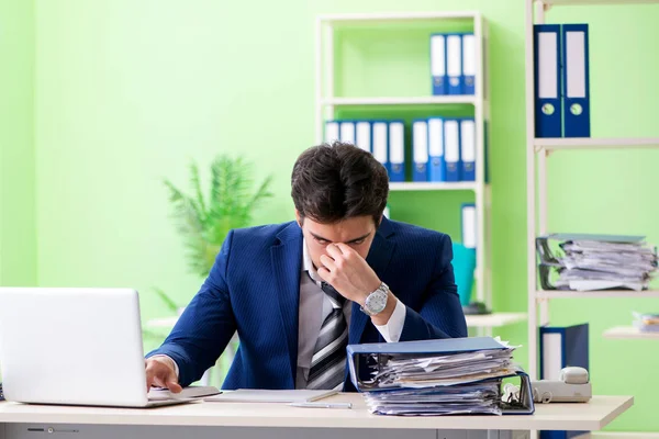 Бизнесмен недоволен чрезмерной работой, сидя в офисе — стоковое фото