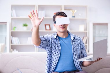 Evde sanal gerçeklik gözlükleriyle serbest çalışan bir öğrenci.