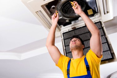 Repairman repairing ceiling air conditioning unit clipart