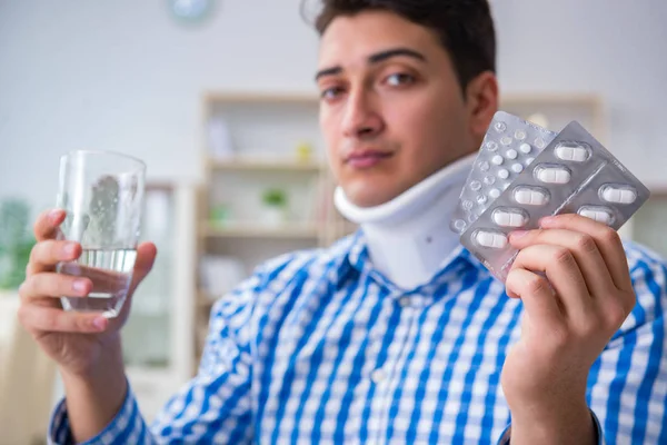 Young man suffering from neck injury at home — Stock Photo, Image