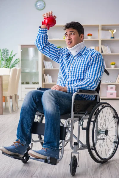Młody mężczyzna na wózku inwalidzkim w domu — Zdjęcie stockowe