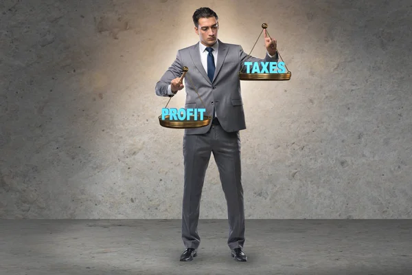 A nyereséget és az adókat összehasonlító üzletember — Stock Fotó