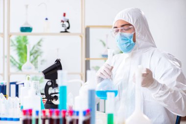 Laboratuvarda kimyasallar üzerinde çalışan genç bir kimyager.