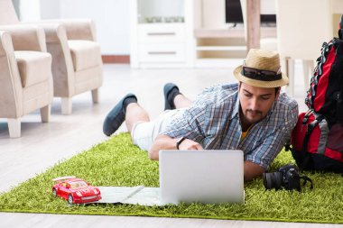 Genç adam internetten seyahat etmeyi planlıyor.