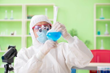 Laboratuvarda yeni bir deney üzerinde çalışan kimyager.