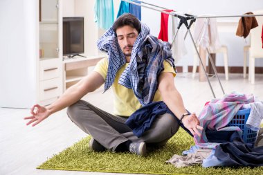 Yakışıklı koca evde çamaşır yıkıyor.