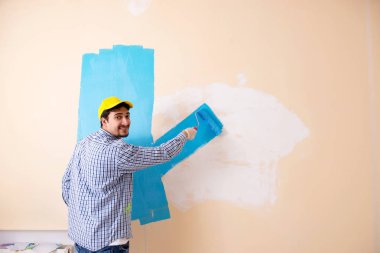 Evdeki duvarı boyayan ressam.