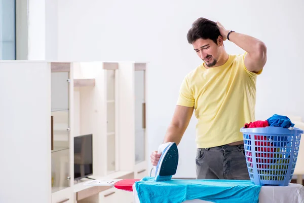 Bonito homem marido fazendo roupas de engomar em casa — Fotografia de Stock