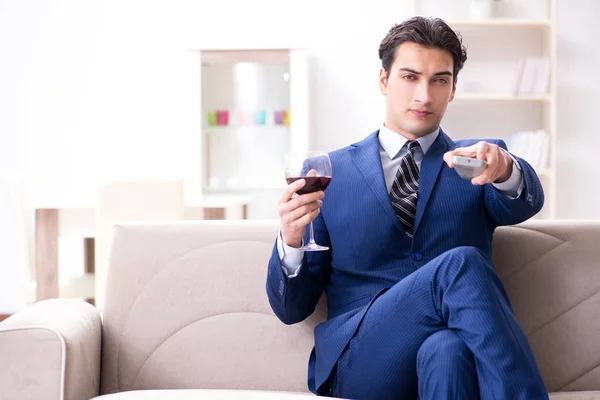 Businessman drinking wine sitting at home — Stock Photo, Image