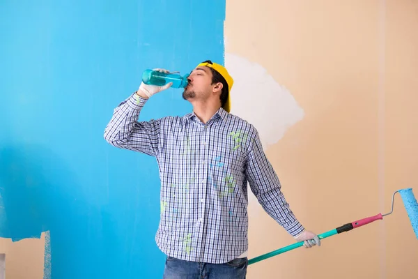 Pintor hombre pintando la pared en casa —  Fotos de Stock