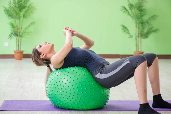 Mujer haciendo ejercicios con pelota suiza — Foto de Stock