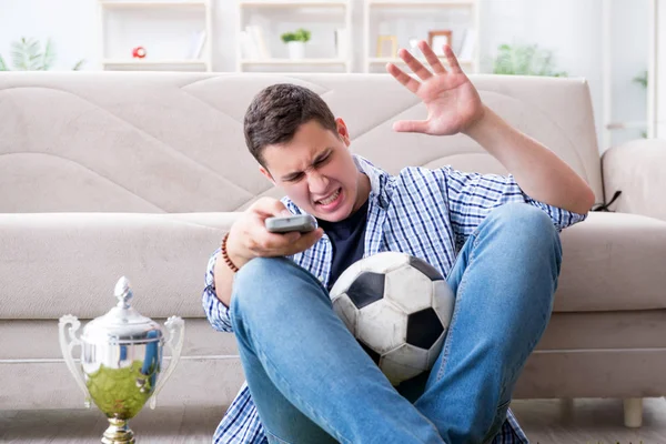 Jovem estudante assistindo futebol em casa — Fotografia de Stock