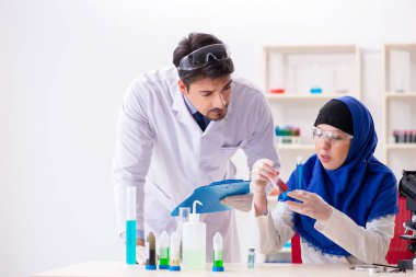 Laboratuvarda çalışan iki kimyager.