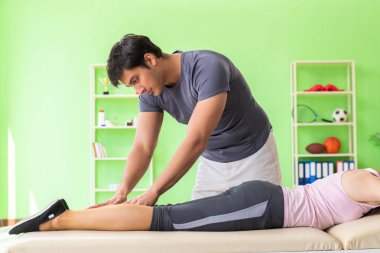 Genç doktor masör hastaya masaj yapıyor. 