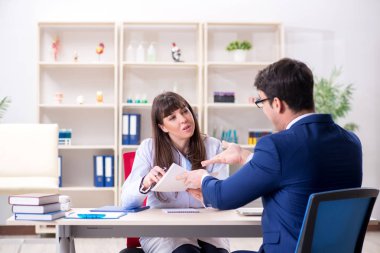 İş adamı doktorla sağlık sorunlarını tartışıyor