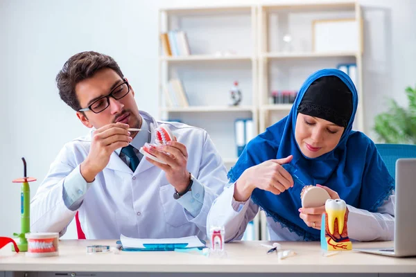 Diş hekimi ve asistanı yeni diş implantı üzerinde çalışıyor.