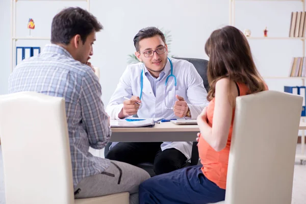 Mujer embarazada con su marido visitando al médico en la clínica — Foto de Stock