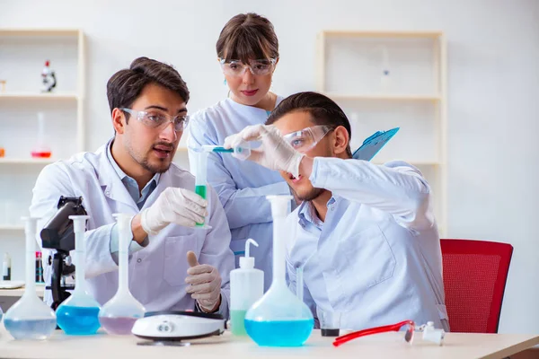 Команда химиков, работающих в лаборатории — стоковое фото