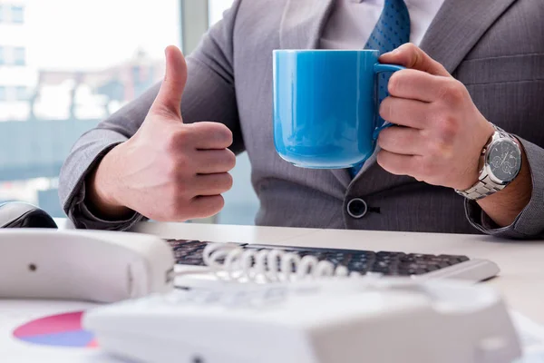Businessman drinking coffee in the office — Stock Photo, Image