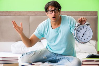 Sınavlara hazırlanan öğrenci yatak odasında oturuyor.