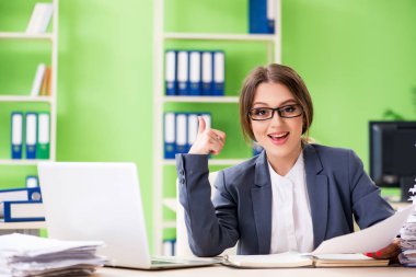 Genç bayan çalışan devam eden evrak işleriyle çok meşgul.