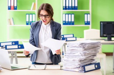 Genç bayan çalışan devam eden evrak işleriyle çok meşgul.
