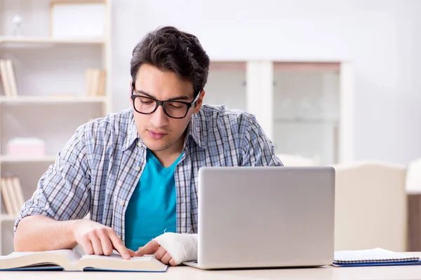 Giovane studente uomo con lesioni alla mano che si prepara per gli esami — Foto Stock