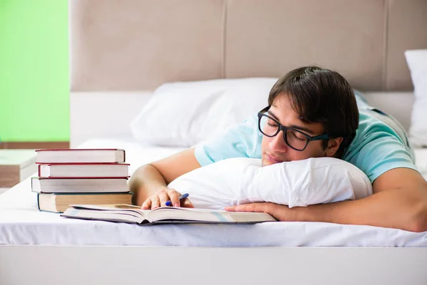 Estudiante preparándose para los exámenes en casa en el dormitorio acostado en la cama —  Fotos de Stock