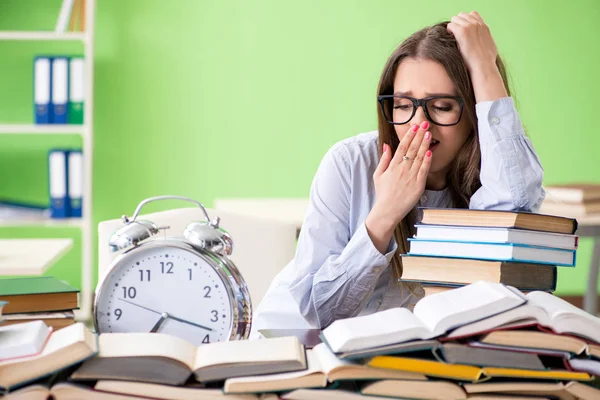 Jonge vrouwelijke student bereidt zich voor op examens met veel boeken in de tijd — Stockfoto