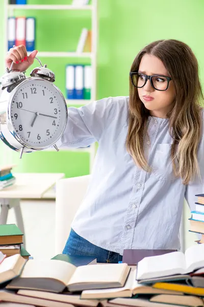 Young female student preparing for exams with many books in time — Stock Photo, Image