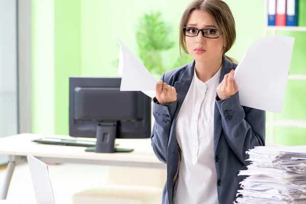 Jeune employée très occupée par la paperasserie en cours — Photo