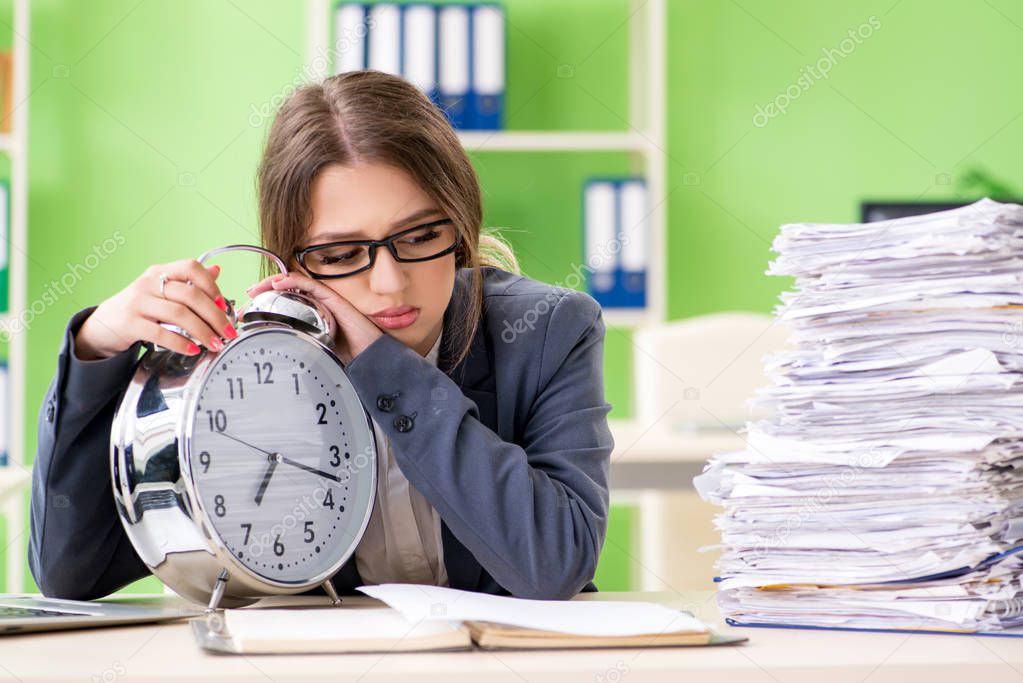 Young female employee very busy with ongoing paperwork in time m
