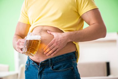 Diyet konseptinde bira tutan şişman obez adam.