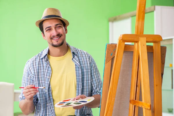 Young male artist working on new painting in his studio — Stock Photo, Image