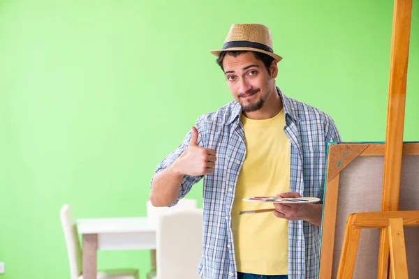 Joven artista masculino trabajando en una nueva pintura en su estudio — Foto de Stock