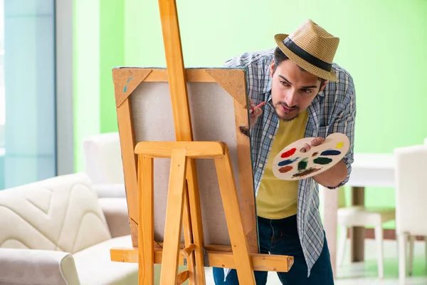 Joven artista masculino trabajando en una nueva pintura en su estudio — Foto de Stock