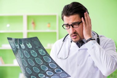 Doktor radyoloji uzmanı hastanede röntgen taramasına bakıyor.